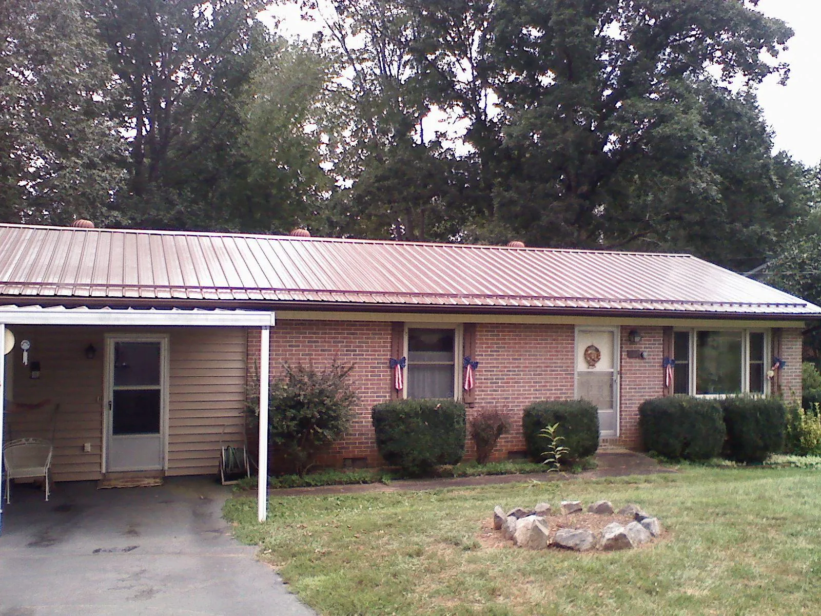 Bronze metal roof and carport on a brick ranch home — Roof Repair work by our crew in Pekin